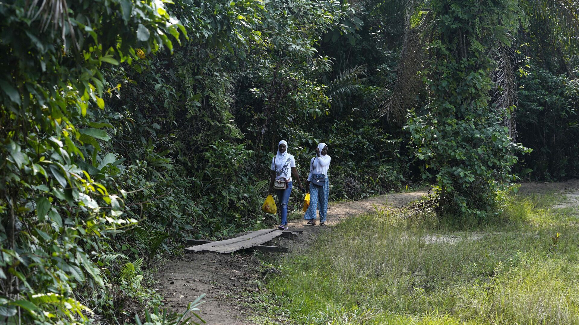 Two women visit the Lufasi Park lake Nora in Lagos, Nigeria, Sunday, Aug. 21, 2022, where some new trees are being planted. Two women visit the Lufasi Park lake Nora in Lagos, Nigeria, Sunday, Aug. 21, 2022, where some new trees are being planted. - Sputnik Africa, 1920, 21.03.2023
