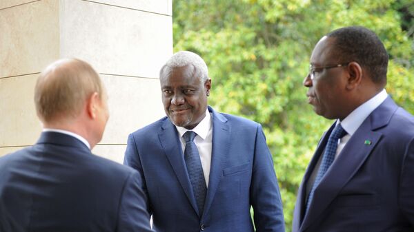 Russian President Vladimir Putin, left, shakes hands with African Union Commission (AUC) Chairperson Moussa Faki Mahamat before a meeting to discuss preparations for the next Russia-Africa summit and food security issues at the Bocharov Ruchei residence in the resort city of Sochi, Russia. Senegalese President Macky Sall, who is currently that chairman of the African Union, is at right. June 03, 2022. - Sputnik Africa