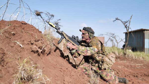 A soldier shuffles back to position to fire his machine gun during a simulated military excercise of the British Army Training Unit in Kenya (BATUK) together with the Kenya Defence Forces (KDF) at the ol-Daiga ranch, high on Kenya’s Laikipia plateau on March 27, 2018.  - Sputnik Africa