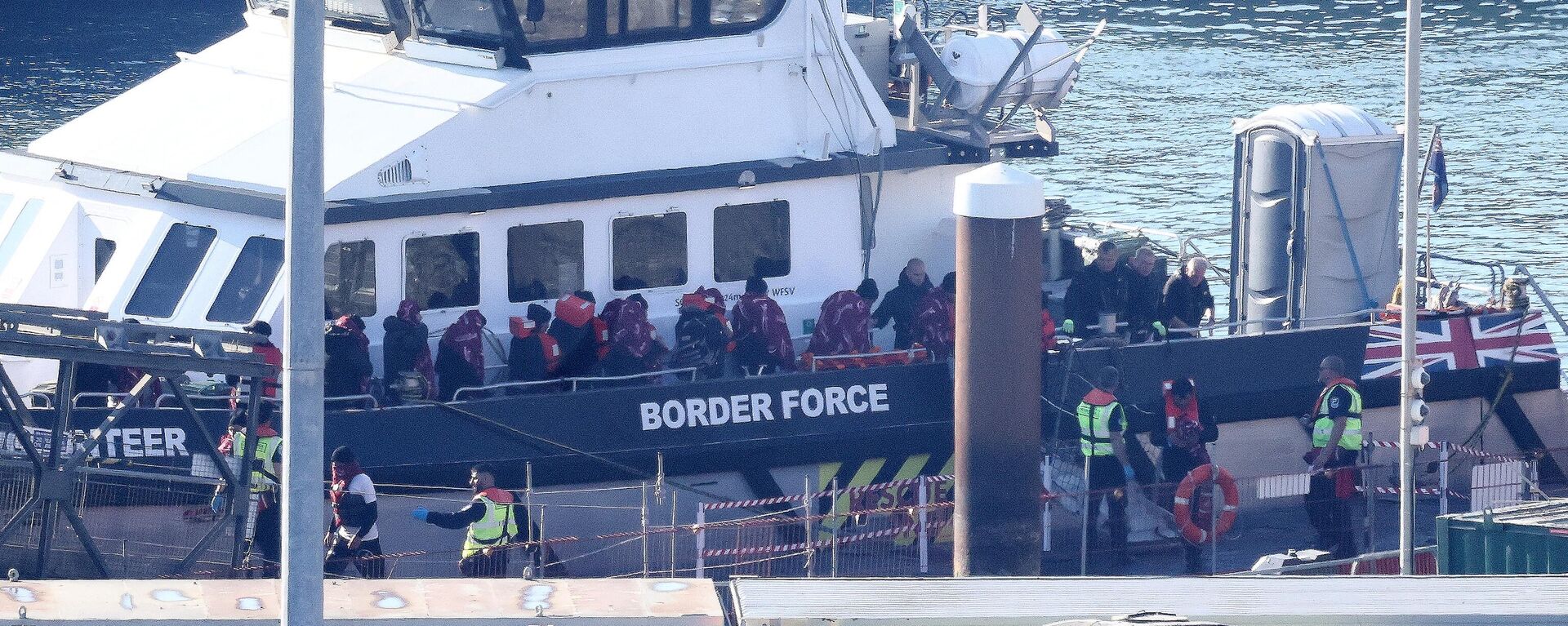 Migrants are escorted ashore from a UK Border Force vessel in Dover, southeast England, on June 15, 2023, after having been picked up at sea while attempting to cross the English Channel. - Sputnik Africa, 1920, 30.11.2023