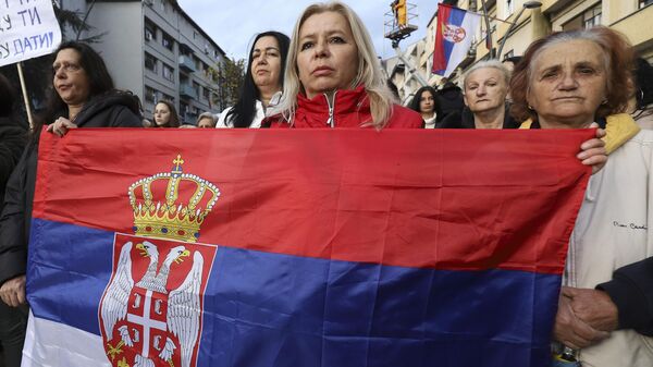 Women hold Serbia's flag as they march in the northern part of Kosovska Mitrovica, Kosovo, Wednesday, Nov. 23, 2022. Serbs in the northern part of Kosovska Mitrovica protested against planned fines by Kosovo authorities for those who refuse to change their Belgrade issued vehicle registration plates and against the cruelty they say are facing daily from the authorities in Pristina. - Sputnik Africa