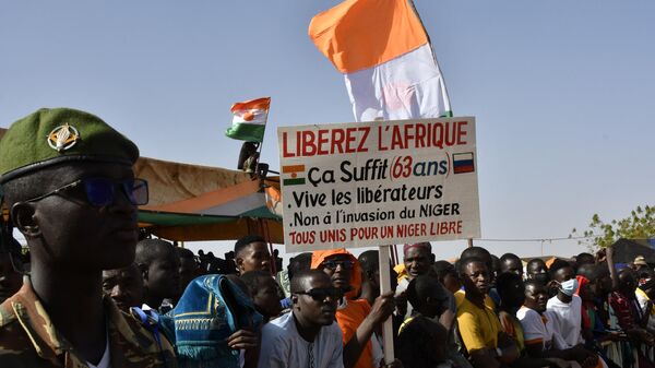 A man holds a sign reading Liberate Africa during a gathering in Niamey on December 29, 2023.  - Sputnik Africa
