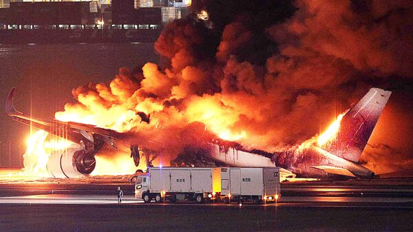 This photo provided by Jiji Press shows a Japan Airlines plane on fire on a runway of Tokyo's Haneda Airport on January 2, 2024. - Sputnik Africa
