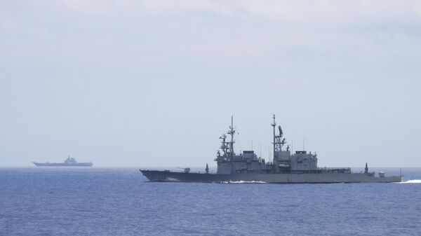 In this file photo released by the Taiwan Ministry of National Defense, Taiwanese navy ship Keelung, foreground, a US made Kidd Class destroyer, monitors the Chinese aircraft carrier Shandong, background, near the Taiwanese waters in September 2023. - Sputnik Africa