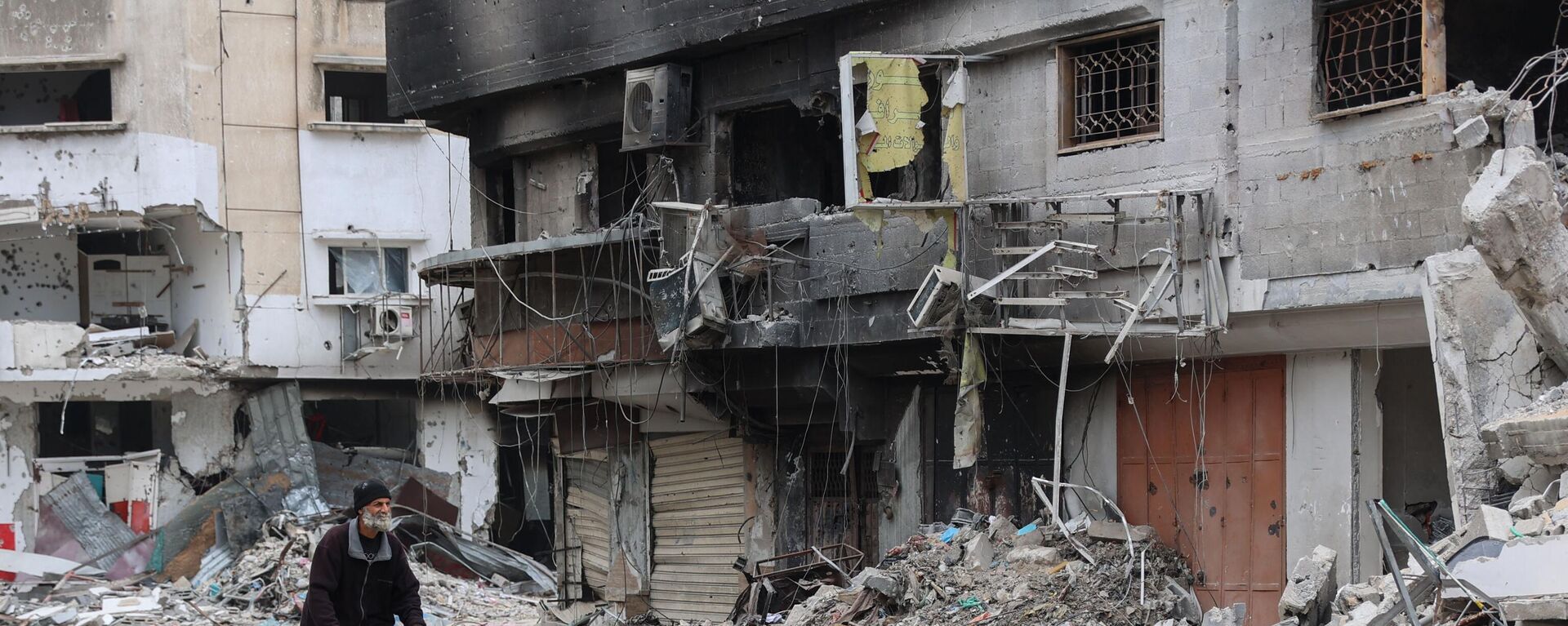 A Palestinian man rides a bicycle past the ruins of a building destroyed by earlier Israeli bombardment in Gaza City on April 8, 2024, amid the ongoing conflict between Israel and the Palestinian Hamas militant group.  - Sputnik Africa, 1920, 04.05.2024