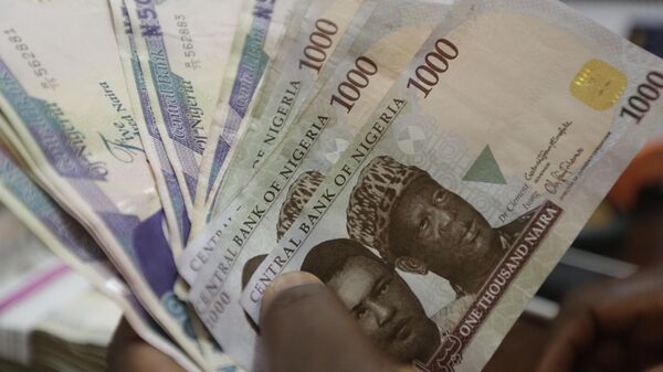 A money changer counts Nigerian naira currency at a bureau de change, in Lagos, Nigeria, on Oct. 20, 2015.  - Sputnik Africa
