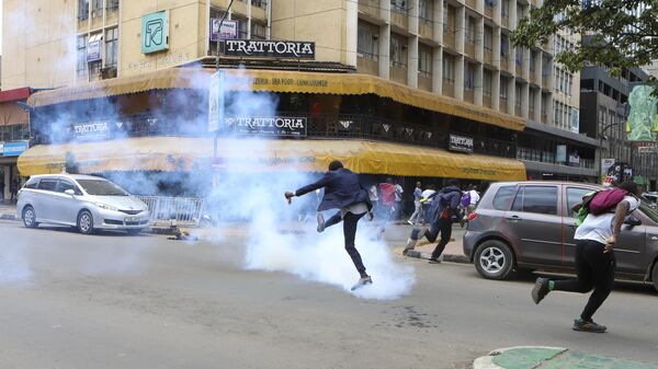 A demonstrator kicks back a tear gas canister during a protest against proposed tax hikes in a finance bill that is due to be tabled in parliament in Nairobi, Kenya, Tuesday, June 18, 2024. - Sputnik Africa