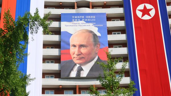 Banner with a portrait of Russian President Vladimir Putin on a building in Pyongyang - Sputnik Africa