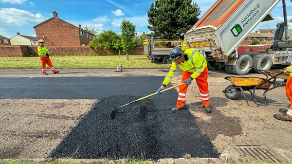 Highway maintenance contractors resurface a worn out road that was full of potholes on May 10, 2024 in Gloucester, England.  - Sputnik Africa