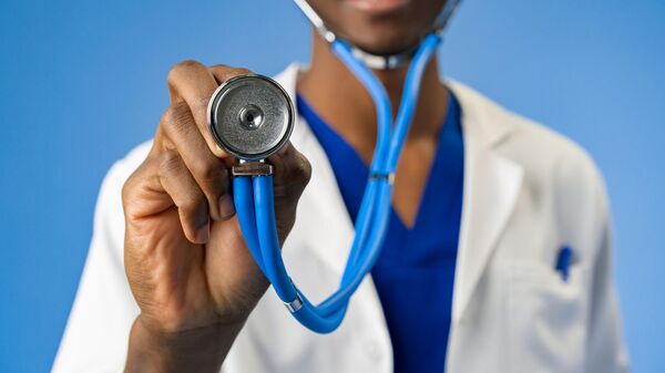 Cropped photo of an African medical doctor with stethoscope on blue background. - Sputnik Africa