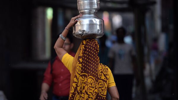 An Indian woman carries drinking water containers - Sputnik Afrique