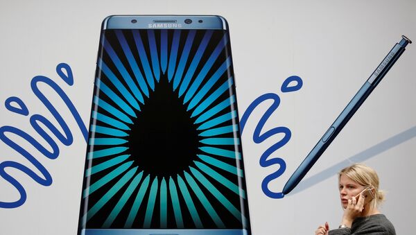 A woman speaks on an Apple phone as she passes an advert for the Samsung Galaxy Note 7 in London, Britain, September 2, 2016. - Sputnik Afrique