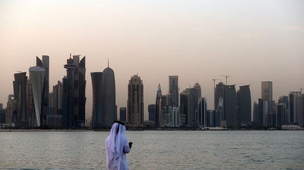 A man looks at his phone on the corniche in the Qatari capital Doha on July 2, 2017. - Sputnik Afrique