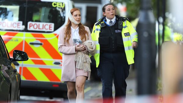 An injured woman is led away after an incident at Parsons Green underground station in London, Britain, September 15, 2017 - Sputnik Afrique