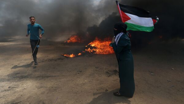 Des manifestants avec un drapeau palestinien, le 14 mai 2018 - Sputnik Afrique