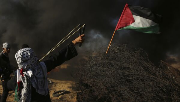 A female protester hurls a stone while others burn tires near the fence of the Gaza Strip border with Israel, during a protest east of Khan Younis, southern Gaza Strip, Friday, Aug. 10, 2018. Violence erupted at the Gaza border Friday after the territory's militant Islamic Hamas rulers and Israel appeared to be honoring a cease-fire that ended two days of intense violence amid efforts by neighboring Egypt to negotiate between the two sides - Sputnik Afrique